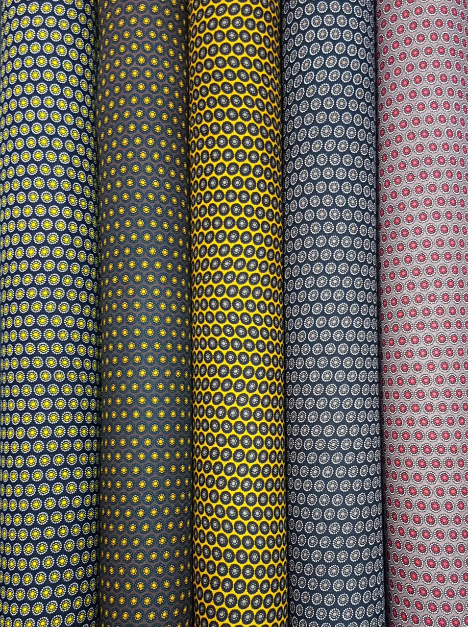 Stripes and Dots13 Collection, all colorways shown together. Tightly packed rows of small round dots set in a honeycomb grid create an allover geometric texture.