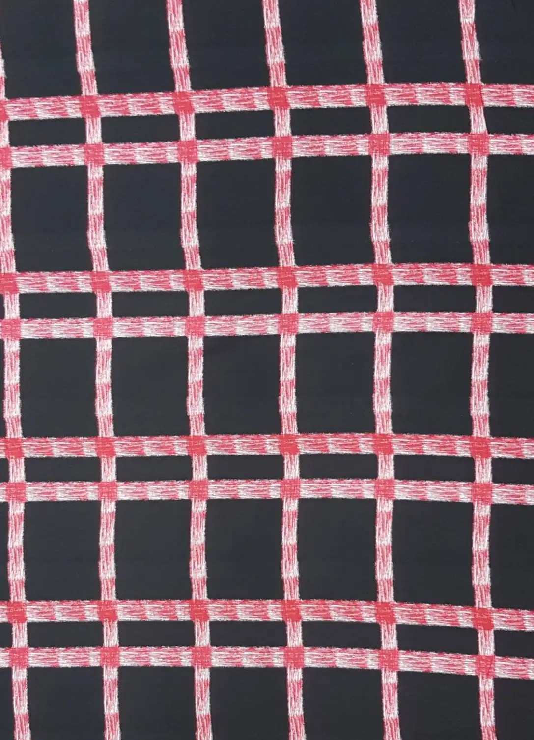 Stripes and Dots7 Collection in Black Red. Deep brown-black ground crossed by hazy red and white grid lines forming an open windowpane check.