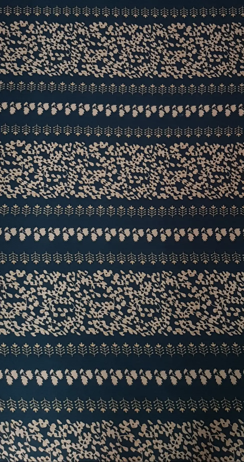 Floral15 Collection in Green. Deep teal-green ground patterned with pale sand-beige leaves, sprigs, and rows of small standing plants.