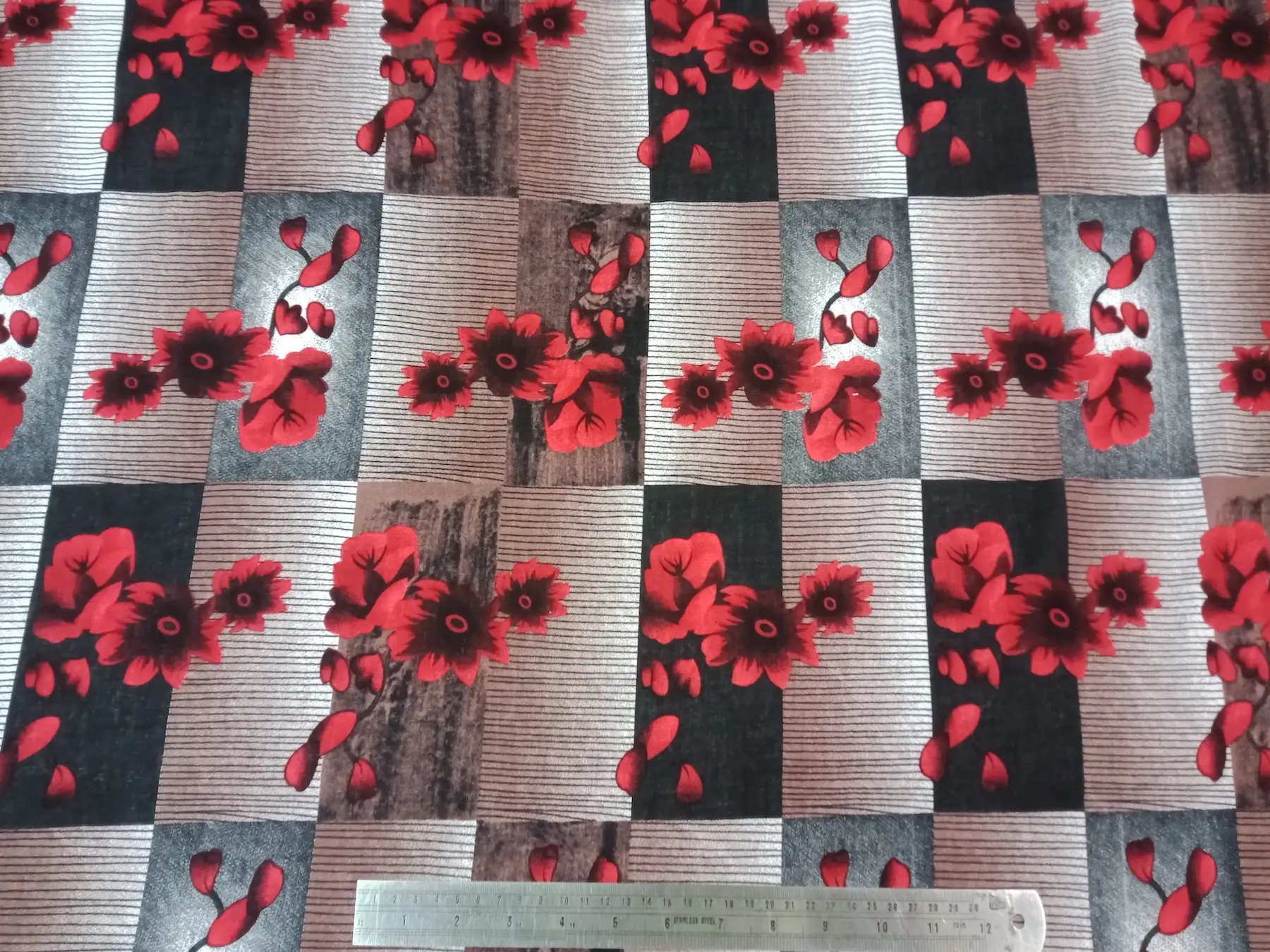 Floral16 Collection in Grey. Soft taupe-grey panels show scattered red flowers and buds over muted brown banding.