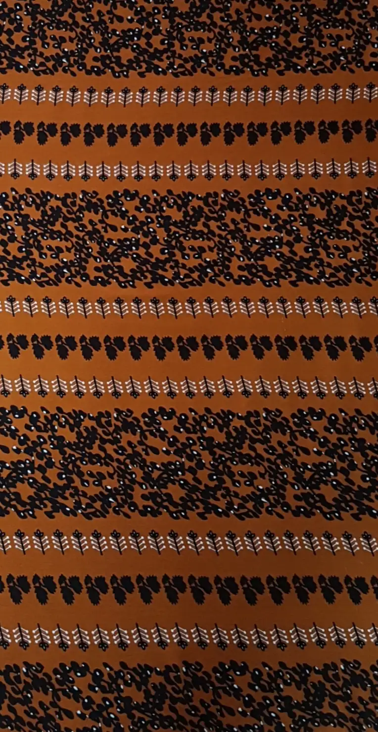 Floral15 Collection in Orange. Warm marigold-orange ground carrying dark brown scattered foliage and brown rows of upright plant motifs.