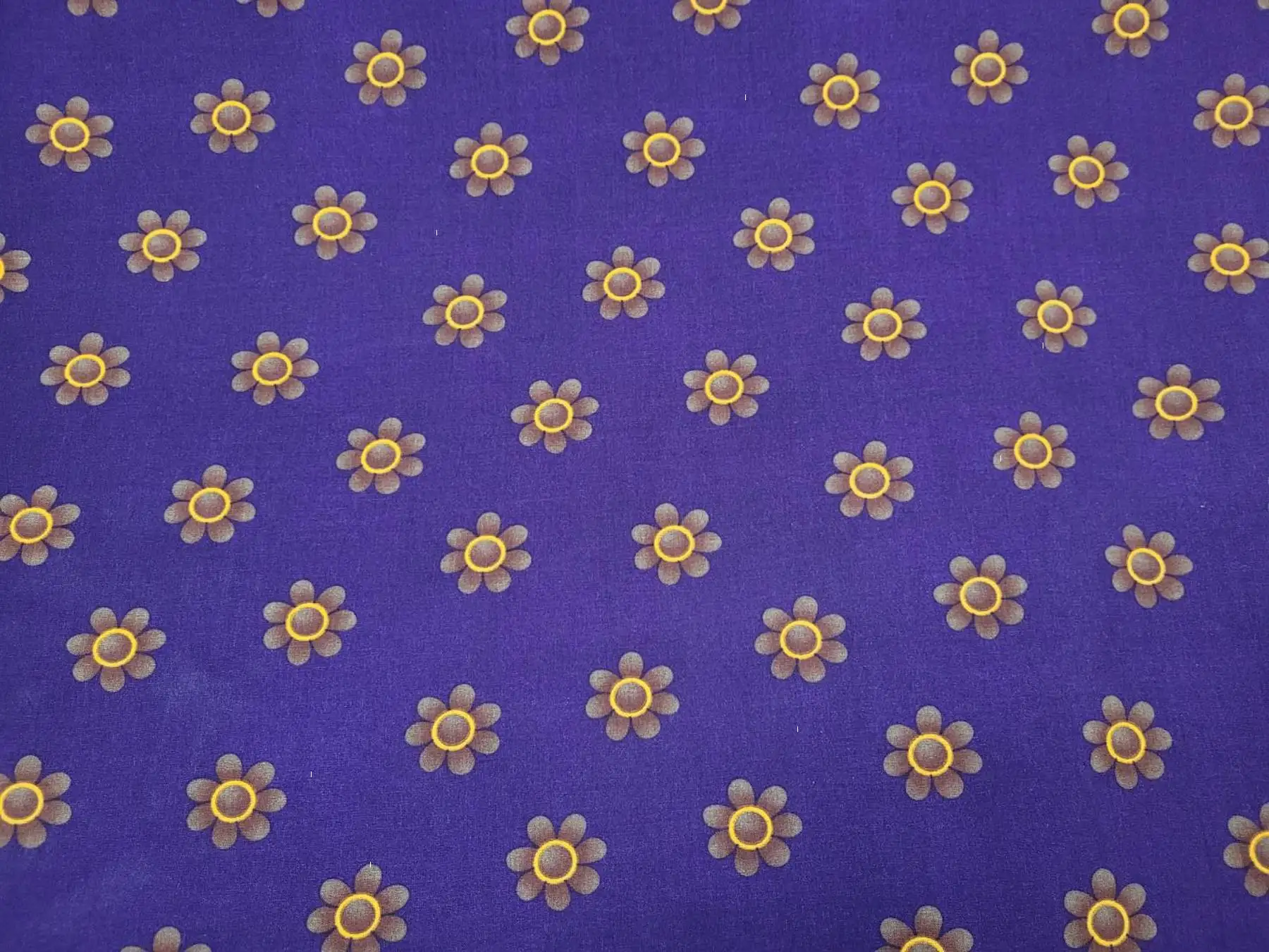 Floral11 Collection in Purple. Bright violet-purple ground dotted with muted mauve and tan flowers around small yellow eyes.