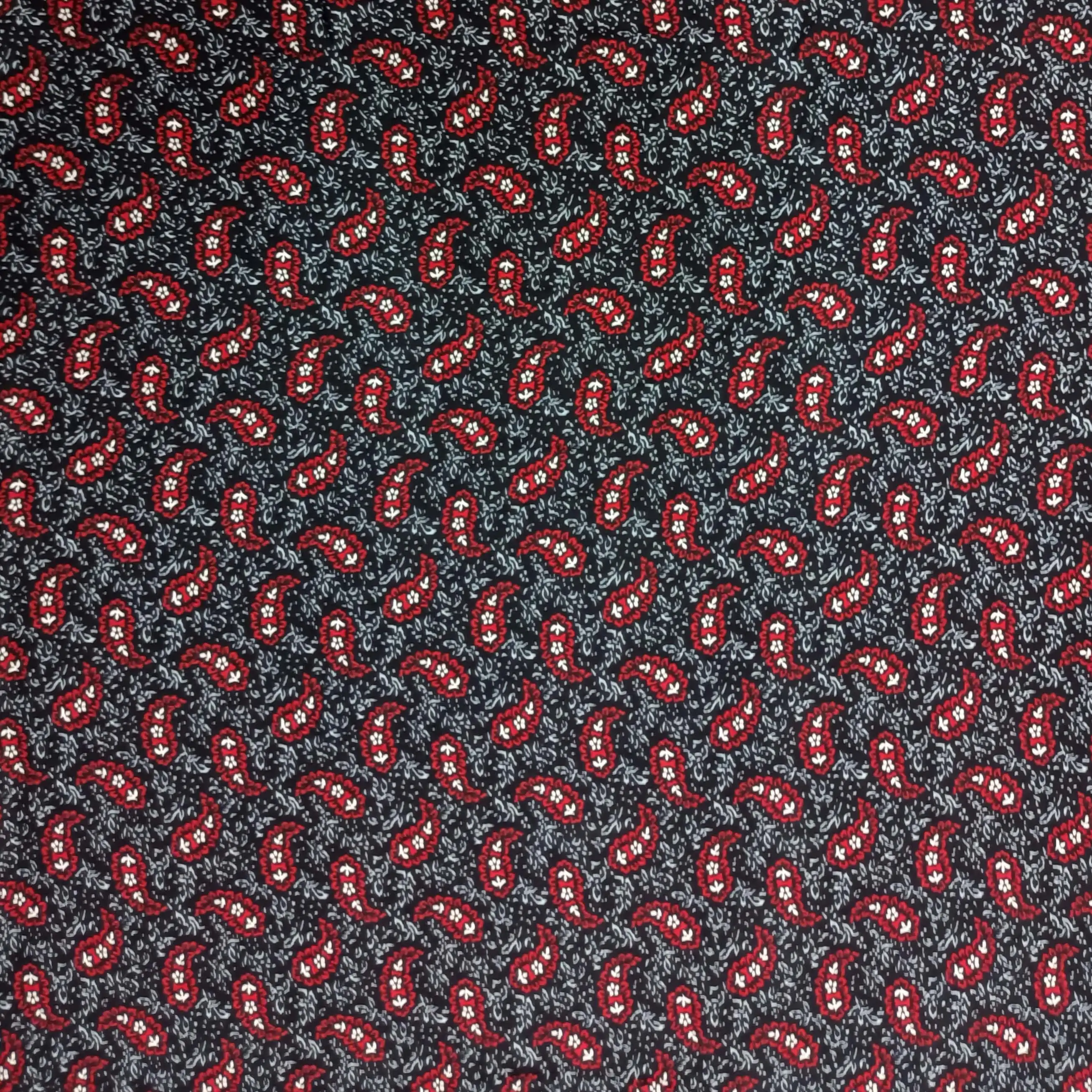 Geometric1 Collection in Red. Near-black ground carrying bright crimson paisleys outlined in white among pale scrolling leaves.