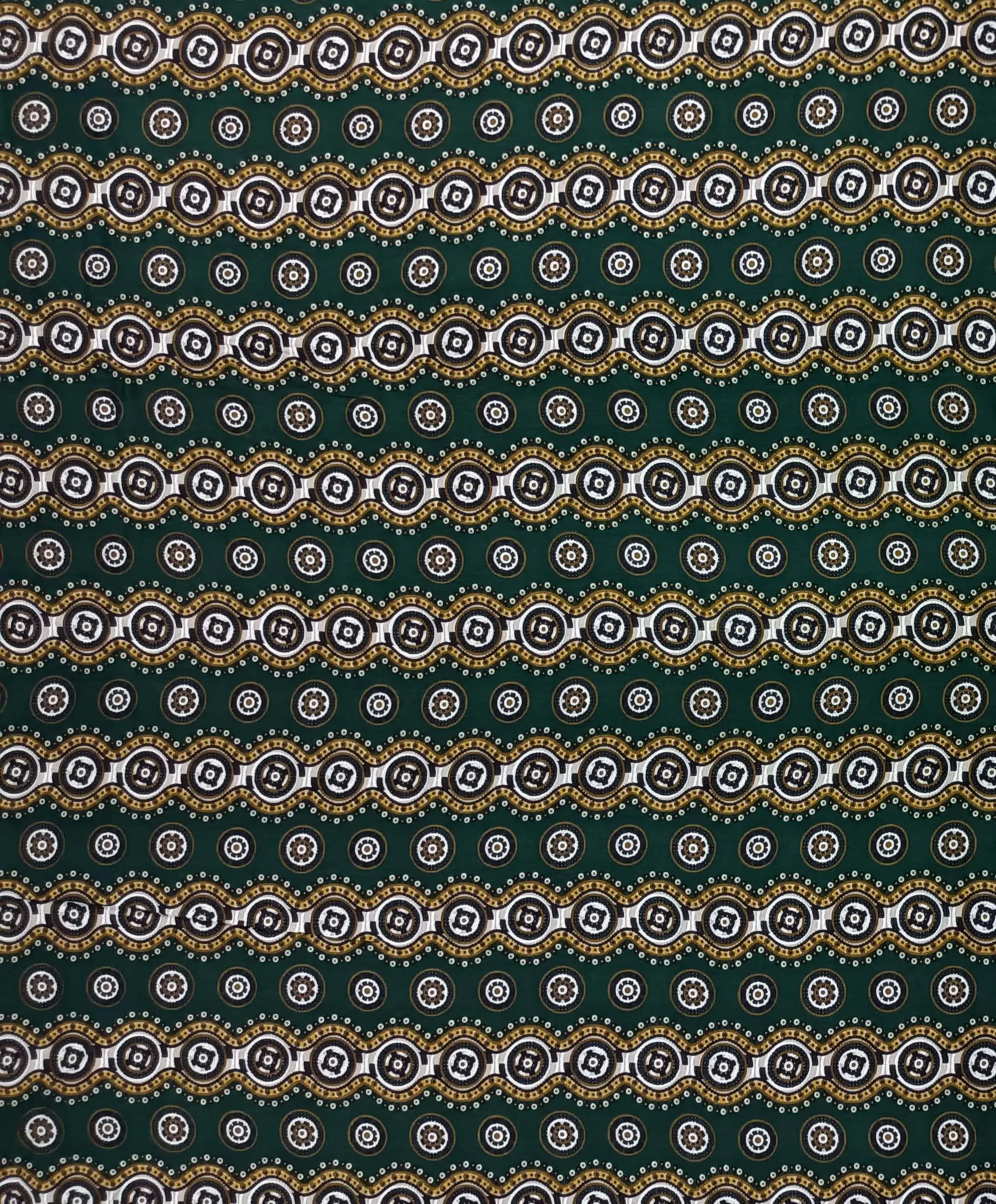 Geometric4 Collection in Green. Warm brown ground showing tan, gold and cream roundels linked by orange beaded arcs.