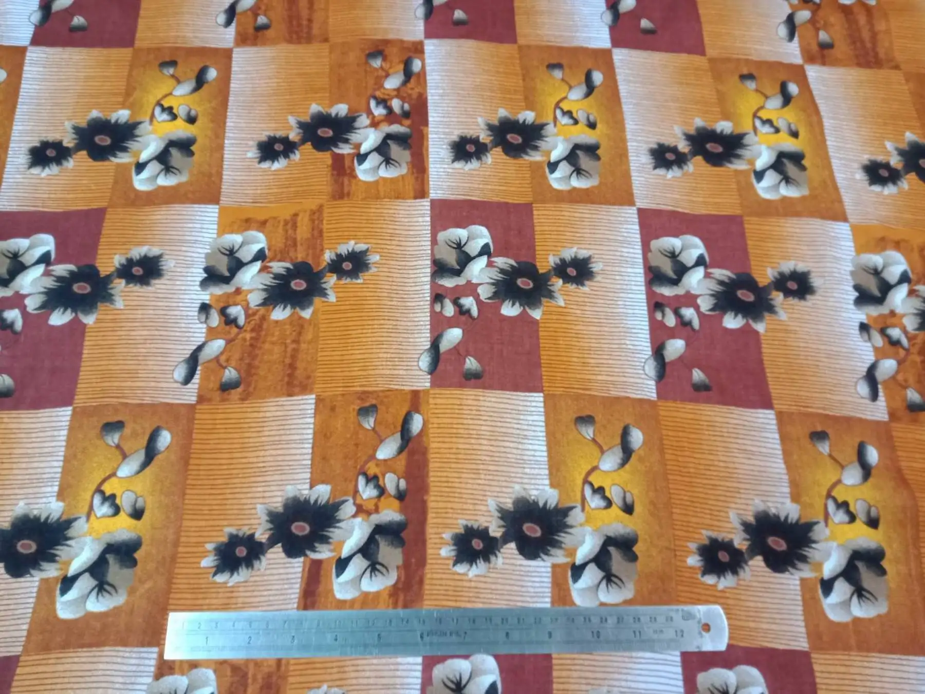 Floral16 Collection in Orange. Warm amber and rust ground with cream and black-centered flowers across woven-look stripes.
