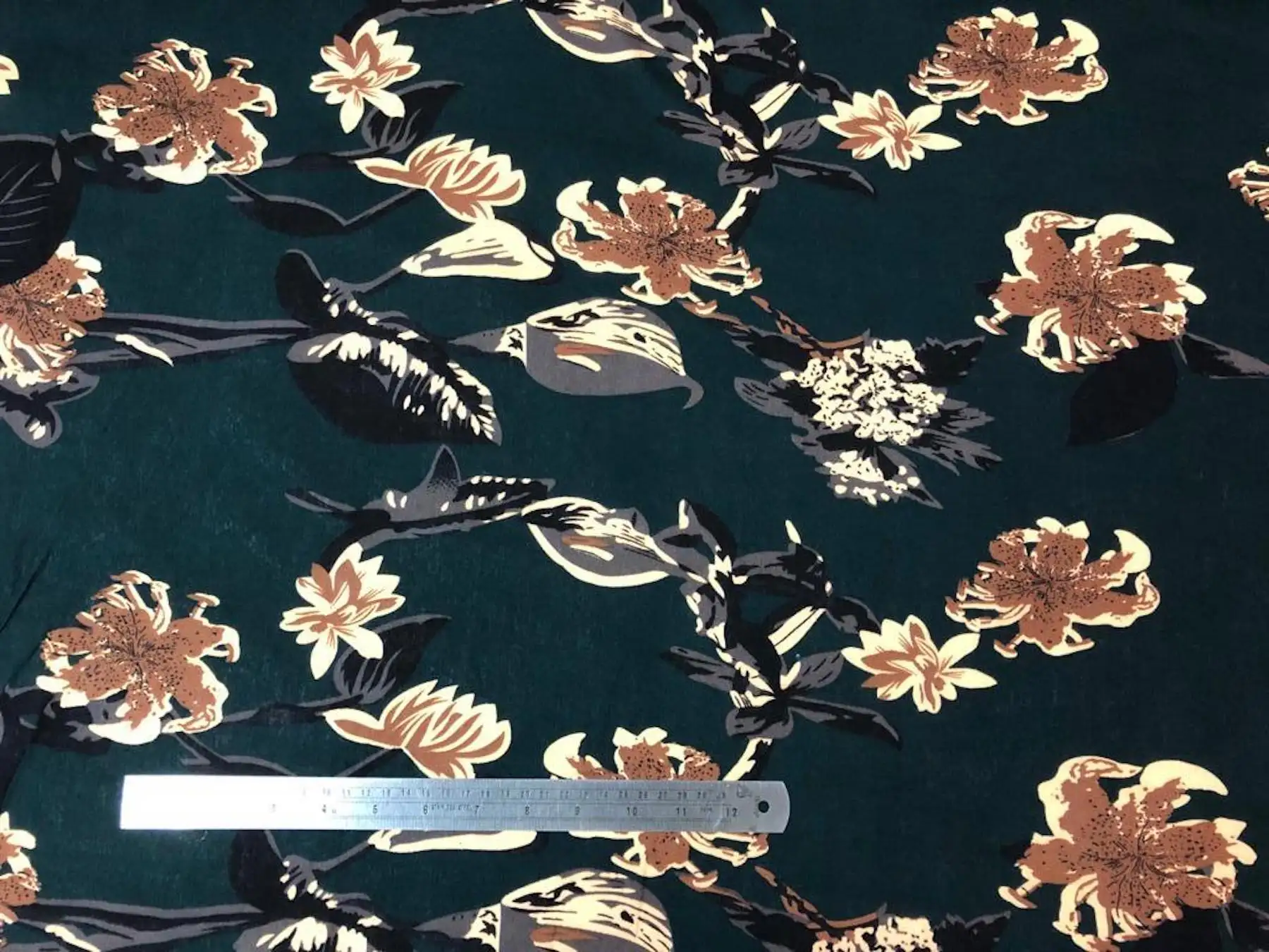 Floral8 Collection in Green Floral. Forest-green ground showing tan and copper-brown flower heads on darker stems.
