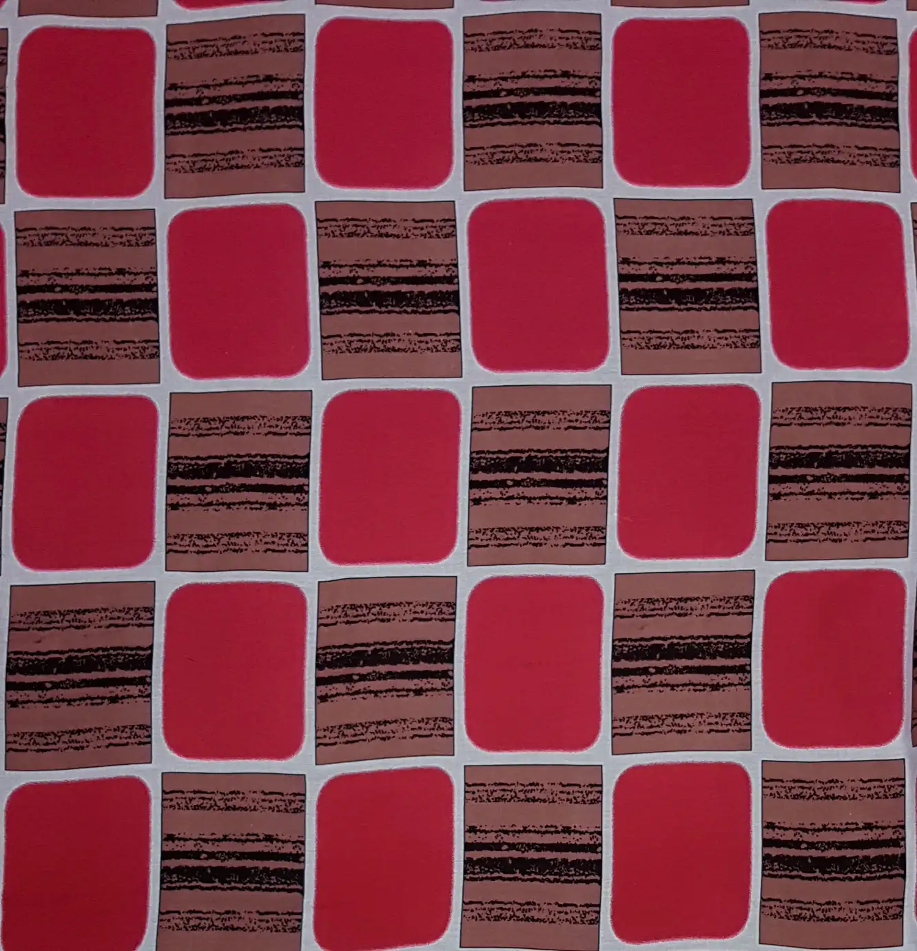 Geometric10 Collection in Red. Coral-red blocks outlined in white on a dusty rose ground with mauve and black stripes.